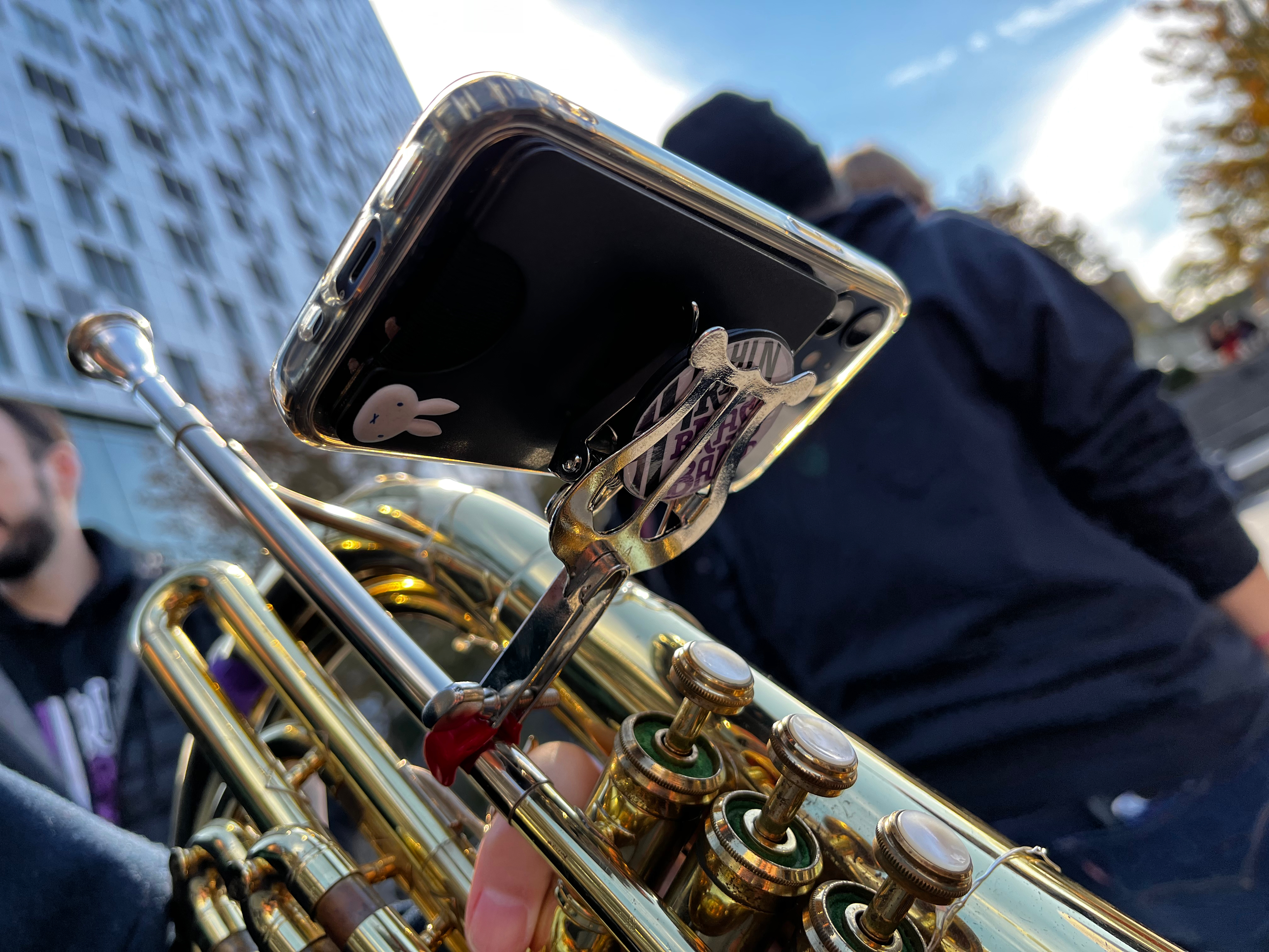 Closeup of a baritone horn with a phone mounted to it via a PopSocket and lyre