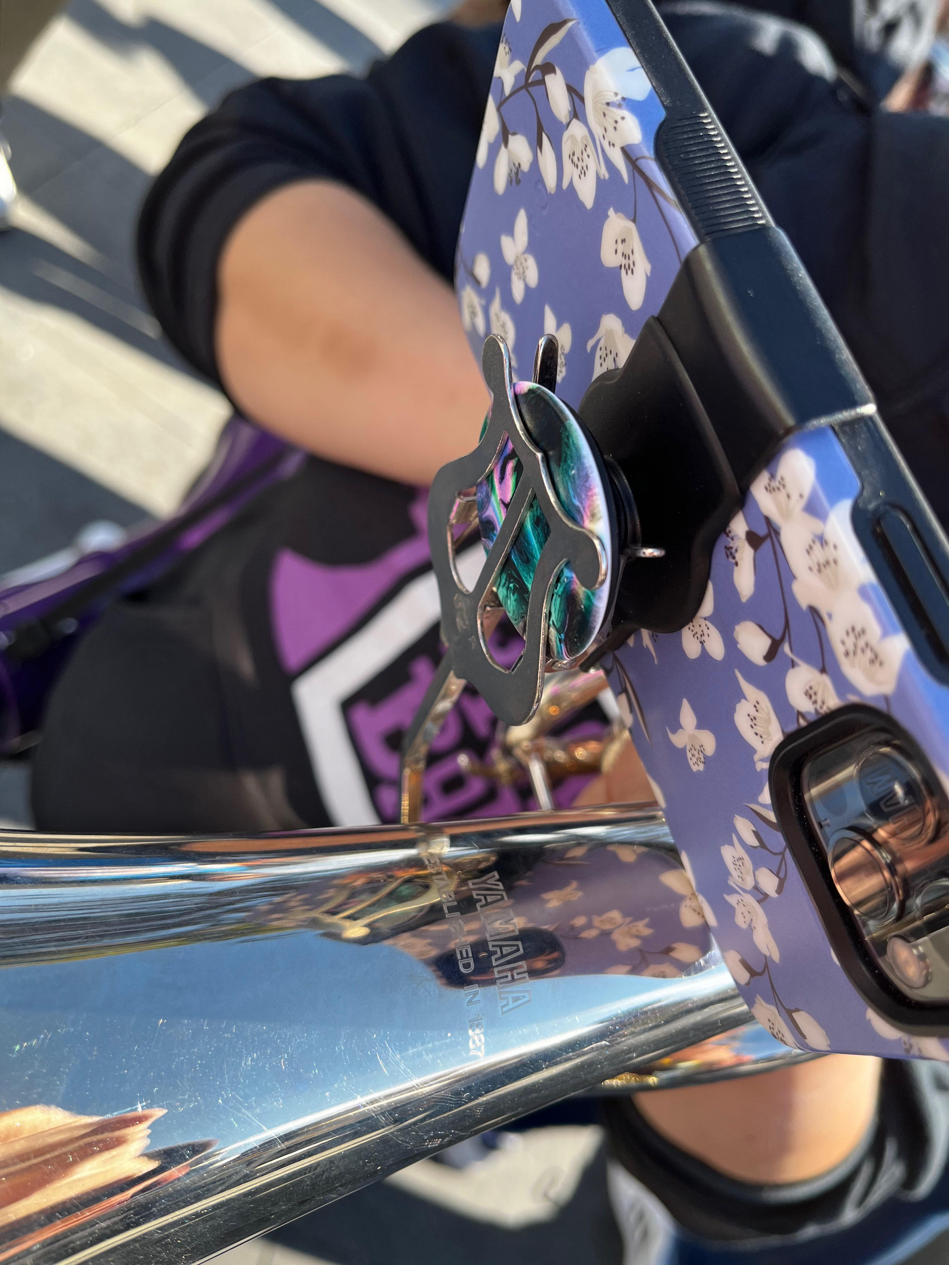 A second closeup of a baritone horn with a phone mounted to it via a PopSocket and lyre